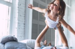 Dad playing with daughter in the bed