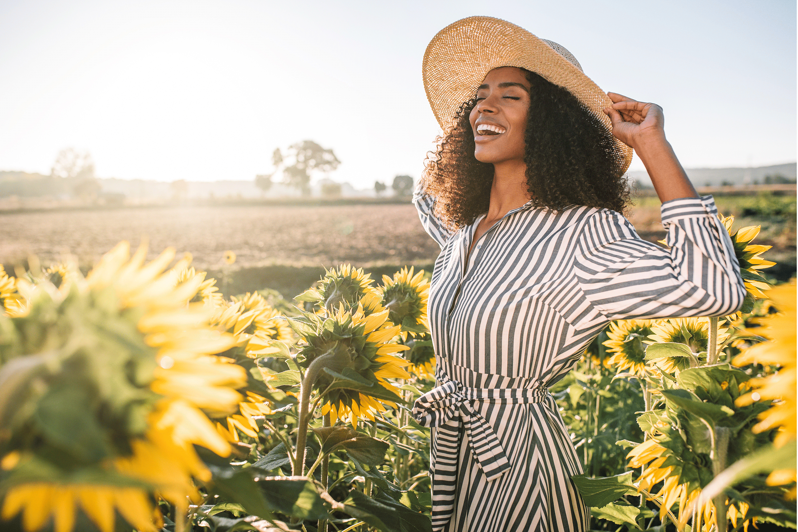 women smiling around sunflowers