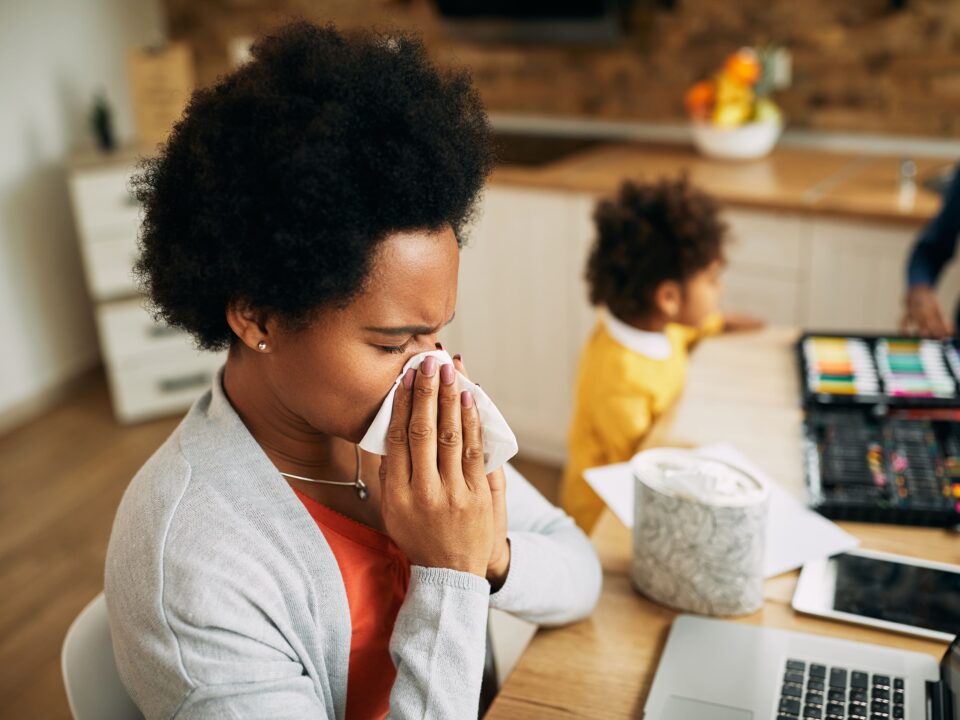 adult woman with cold using tissue indoors
