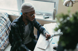 Young man working at his desk in his bedroom.