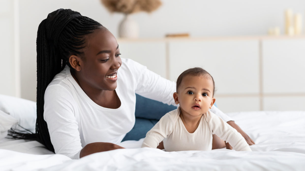 African American woman playing with her adorable black baby