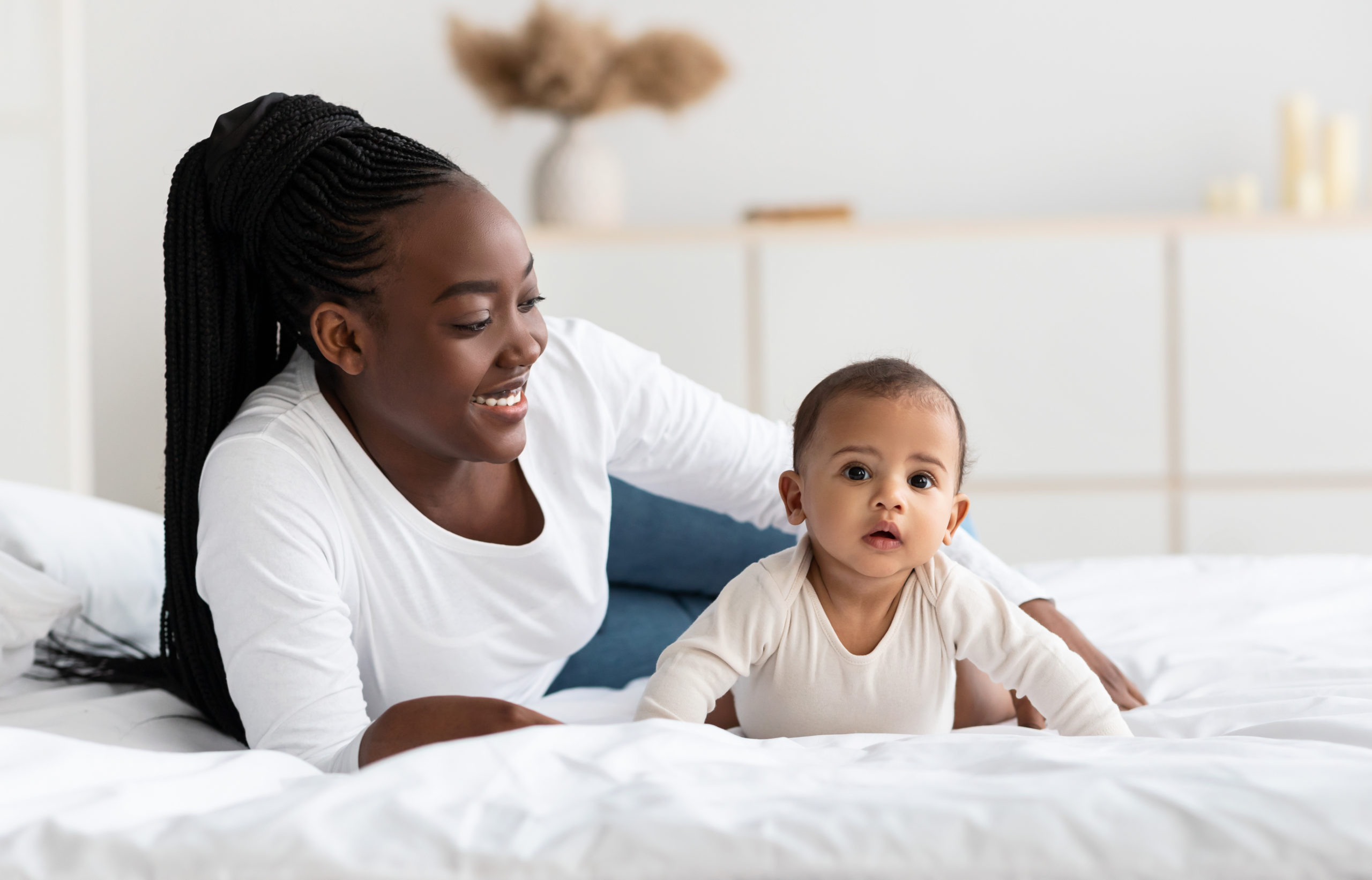 African American woman playing with her adorable black baby