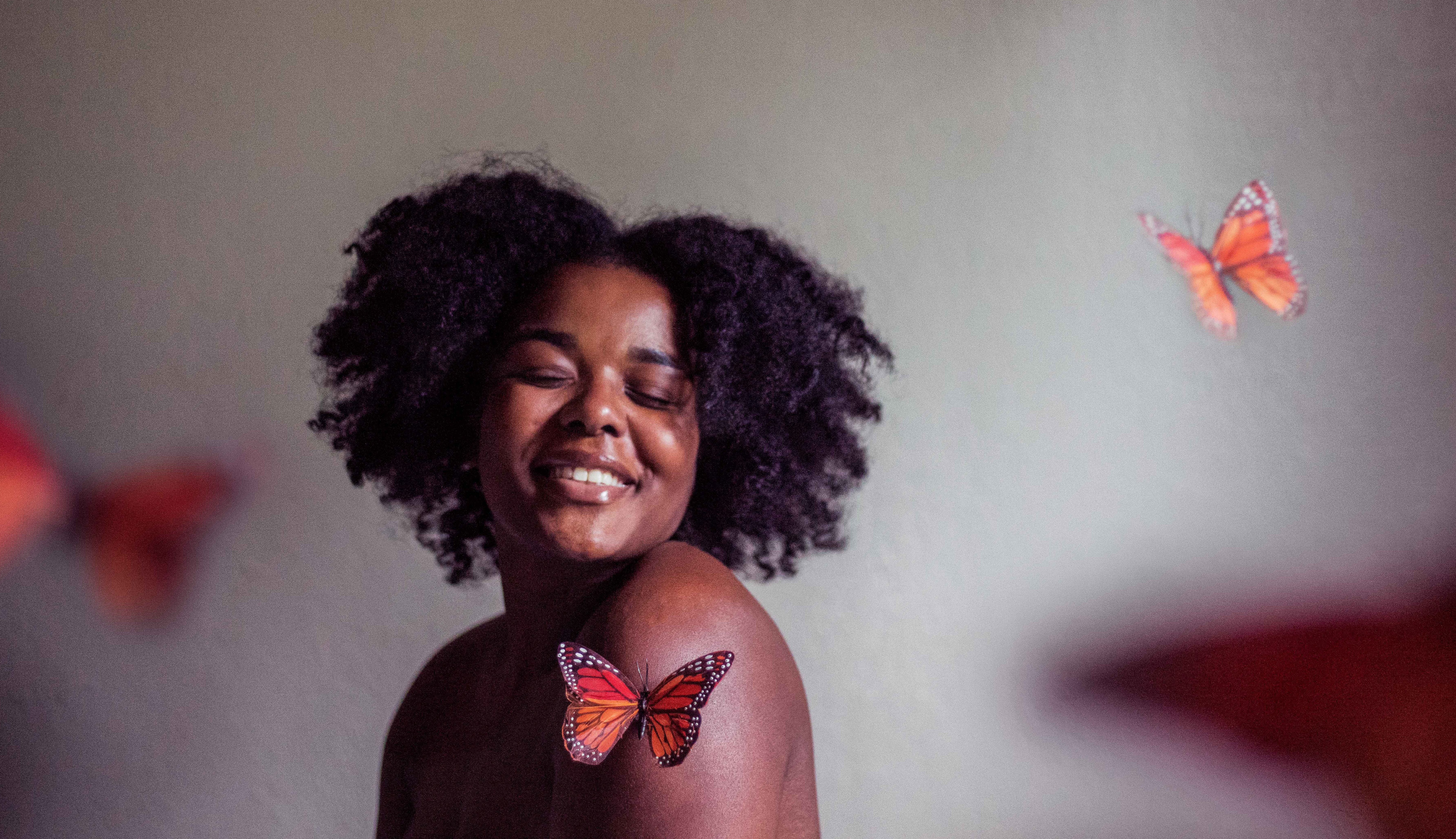 woman smiling with butterflies around her