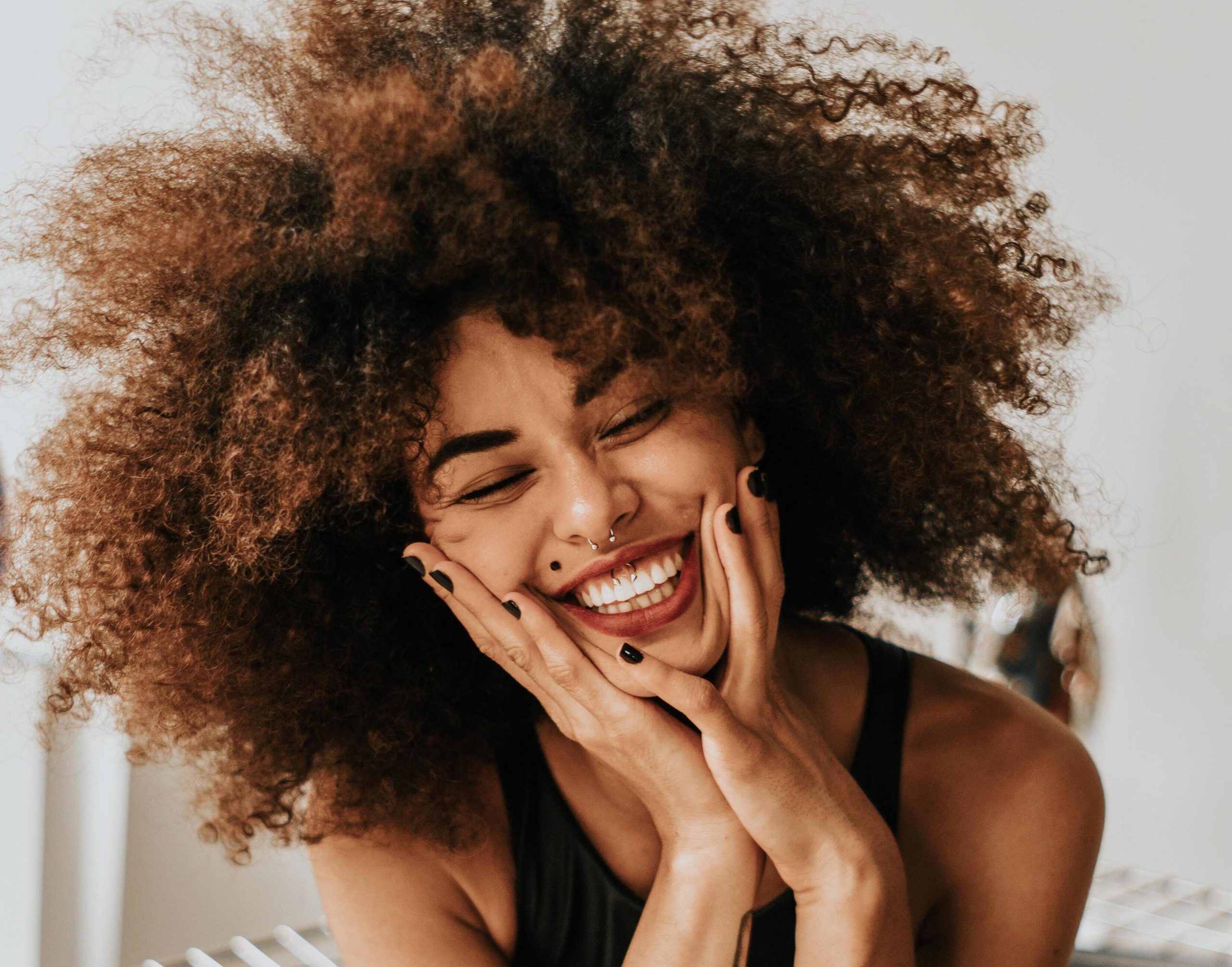 woman smiling with hands on her face