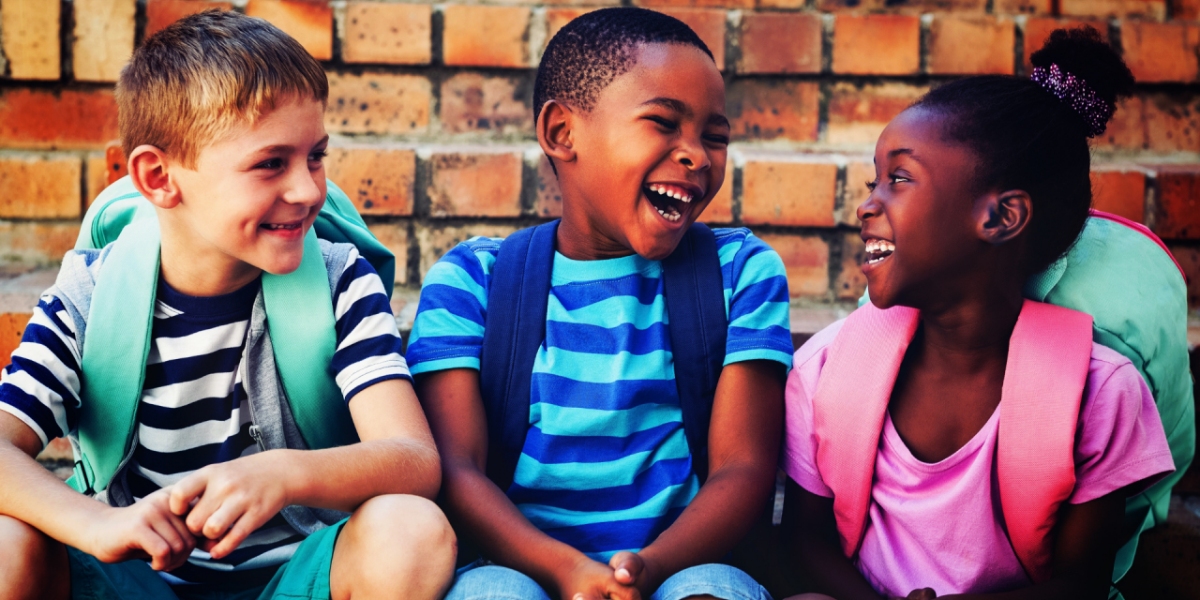 three toddlers laughing with backpack on