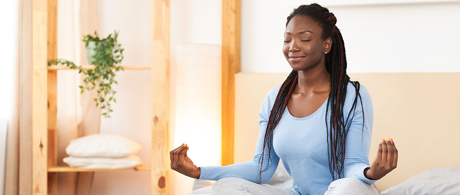 woman meditating on her bed